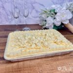 White funeral cake on a wooden table.