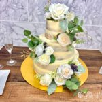Naked rose wedding cake on a wooden table.