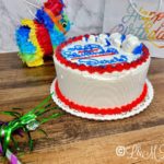 Vanilla cake with blue and red icing on a wooden table.
