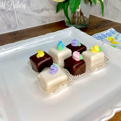 Chocolate and vanilla petit fours on a white serving tray.