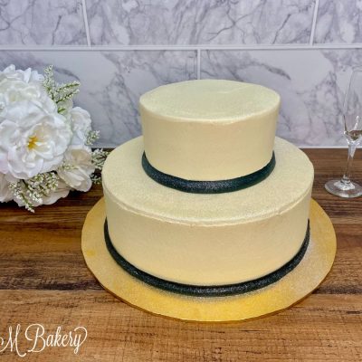 Two tier buttercream wedding cake on a wooden table.