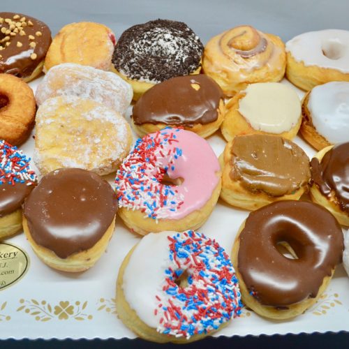 Assorted donuts on a white displayboard.