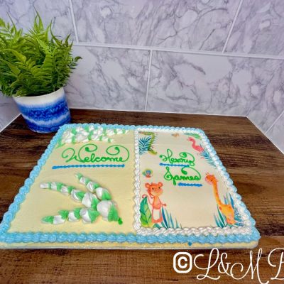 Animal baby shower cake on a wooden table.