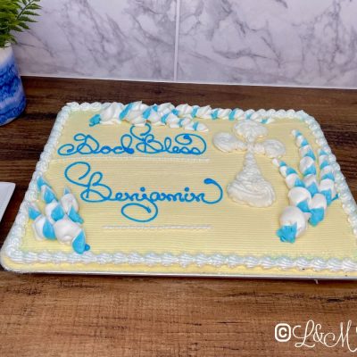 Blue and white baptism cake on a wooden background.