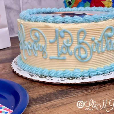 Birthday cake with blue writing on the side.