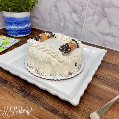 Cannoli cake on a white serving tray.