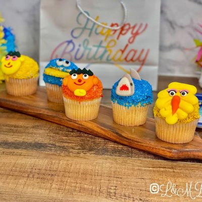 Character cupcakes on a wooden table.