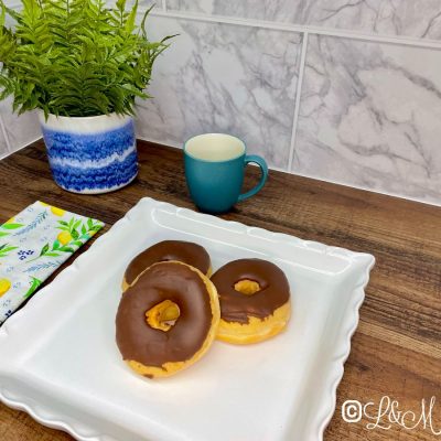 Chocolate ring donut on a white tray.