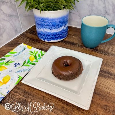 Chocolate donut on a white serving tray.