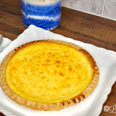 Coconut custard pie on a white serving tray.