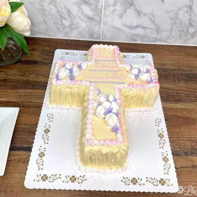 Communion cross cake on a white display board.