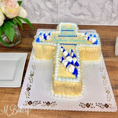Blue and white cross cake on a white display board.