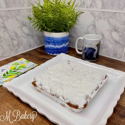 Square crumb cake on a white serving tray.