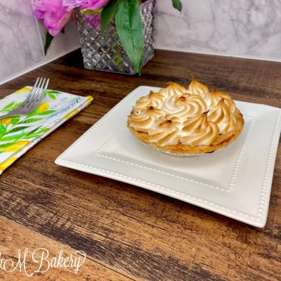 Lemon meringue lunch pie on a white serving tray.