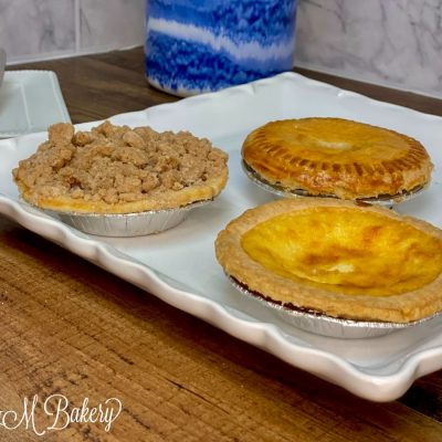 Various lunch pies on a white serving tray.