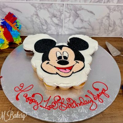 Mickey Mouse cupcake cake on a silver display board.