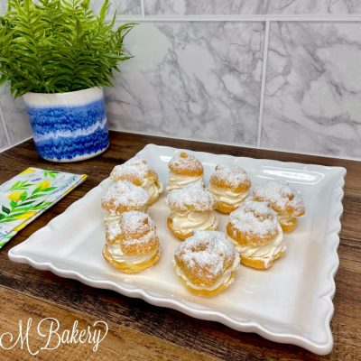 Mini cream puffs on a white serving tray.