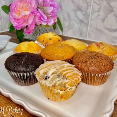 Various muffins on a white serving tray.