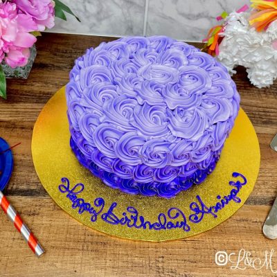 Ombre birthday cake on a wooden table.