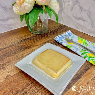 Pound cake slice on a plate on a wooden table.