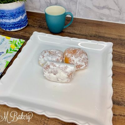 Powder with cream donut on a white serving tray.