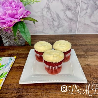 Red velvet cupcakes with buttercream on a white plate.