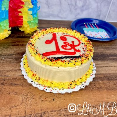 Yellow and red smash cake on a wooden table.