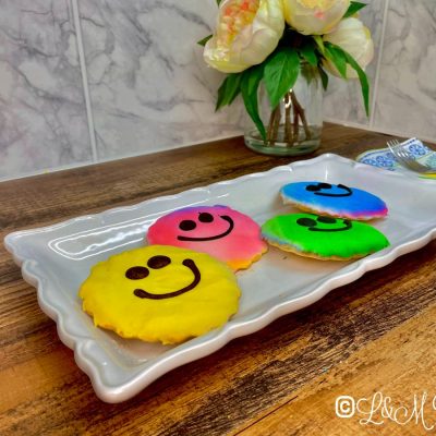 Smiley face cookies on a white plate.