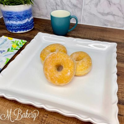Sugar ring donuts on a white plate.