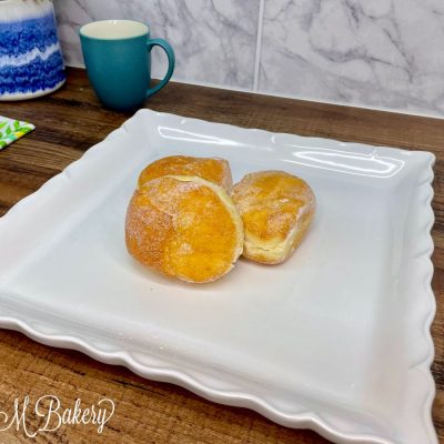 Sugar with cream donut on a white tray.