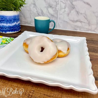 Vanilla ring donut on a white serving plate.